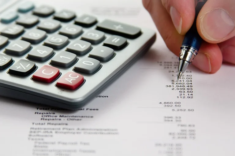 Travail d’analyse financière avec calculatrice et document chiffré, photographie illustrative.