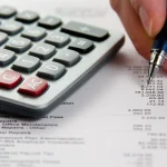 Analyse de données financières avec une calculatrice, photographie illustrative.